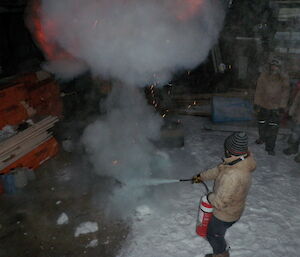 Expeditioner tries to smother flames using a blanket.