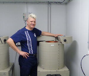 Expeditioner stands next to a round ARPANSA detectors