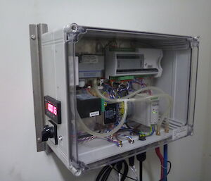 Wires and tubes inside a box mounted on the wall.
