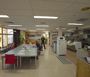 Room with a bain marie and long table for eating at.