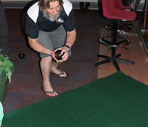 Expeditioner cradles the bowl ready to roll it along the pitch.