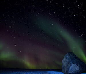 Green streaks of light behind boulders