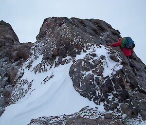 The red jacket of a climber as he climbs the ridge South Doodle