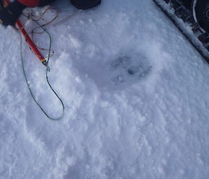 Sea ice drilling measuring tools and the hole that results.