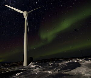 The white Mawson turbine against the white snow and green sky