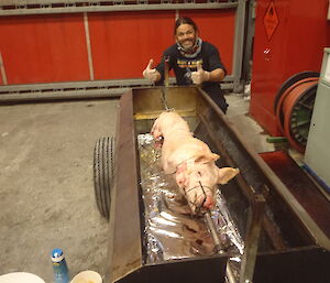 Expeditioner turns the pig on the spit.