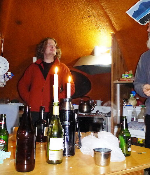 Two people standing inside the hut holding darts