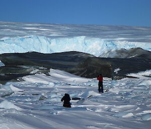 Ice bergs with small figures of people looking around them