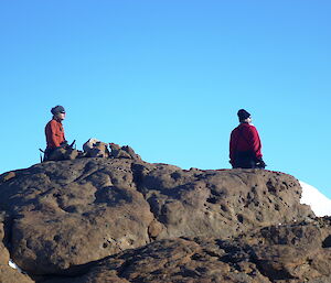 Two poeple sitting on the top of Falla bluff
