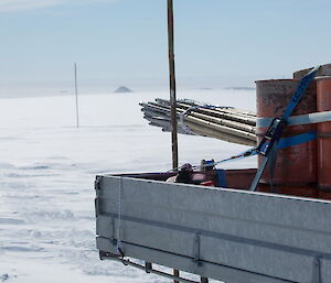 The tray of a ute filled with canes and a veiw of the cnae line in th distance