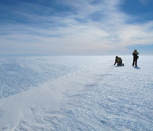 Two expeditioners inspecting a crevasse on Fang route