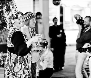 Man and woman enetering a room all dressed up being photographed