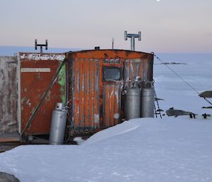 Macey Hut — little red hut aurrounded by ice.