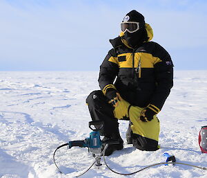 Stewart Cox kneeling on the ice completed covered in wam gear and goggles. Not a bit of human can be seen under all those clothes.