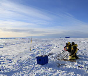 Franmnes Mtns inthe distance, expeditioners working on the weather station in the foreground.