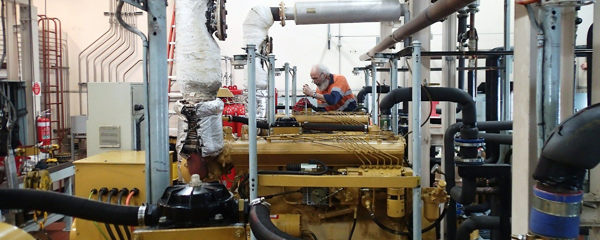 Blokes in the Powerhouse: a room full of pipes and tanks and instruments.