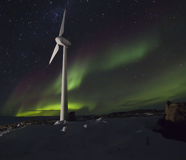 Mawson wind turbine with green aurora in the sky