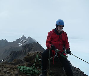 Sixty year old expeditioner on small mountain summit