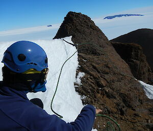 Expeditioner belays a rope along the ridge of the peak