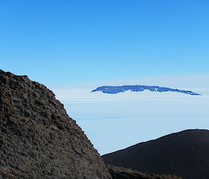 The dark rock of the Casey range rises out of the ice plateau