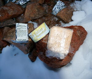 Food cache of Horlicks drinking powder, a tin of butter and biscuit in a plastic cover.