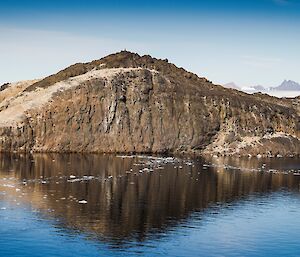 Rookery Island covered in white bird faeces and two figures standing and studying the island.