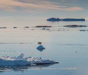 Photos taken from a distance — the red boat looks tiny amongst the rocks and ice bergs.
