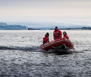 Red inflatable boats with three expeditioners on board.