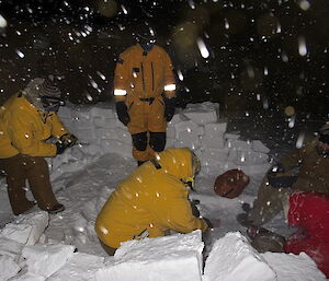 Expeditioners lighting a camp stove during an overnight bivvy