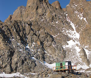 Photo of Rumdoodle hut at the foot of the North Masson Range behind