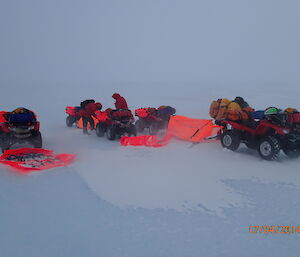 Setting up a quad survival bivvy tent between two Quad Bikes in a blizzard