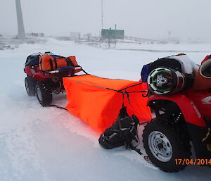 Setting up a quad survival bivvy tent between two Quad Bikes in a blizzard