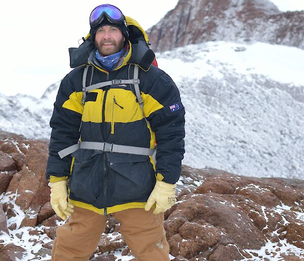 Photograph of Doctor James Chappell standing on a rocky and snowy landscape