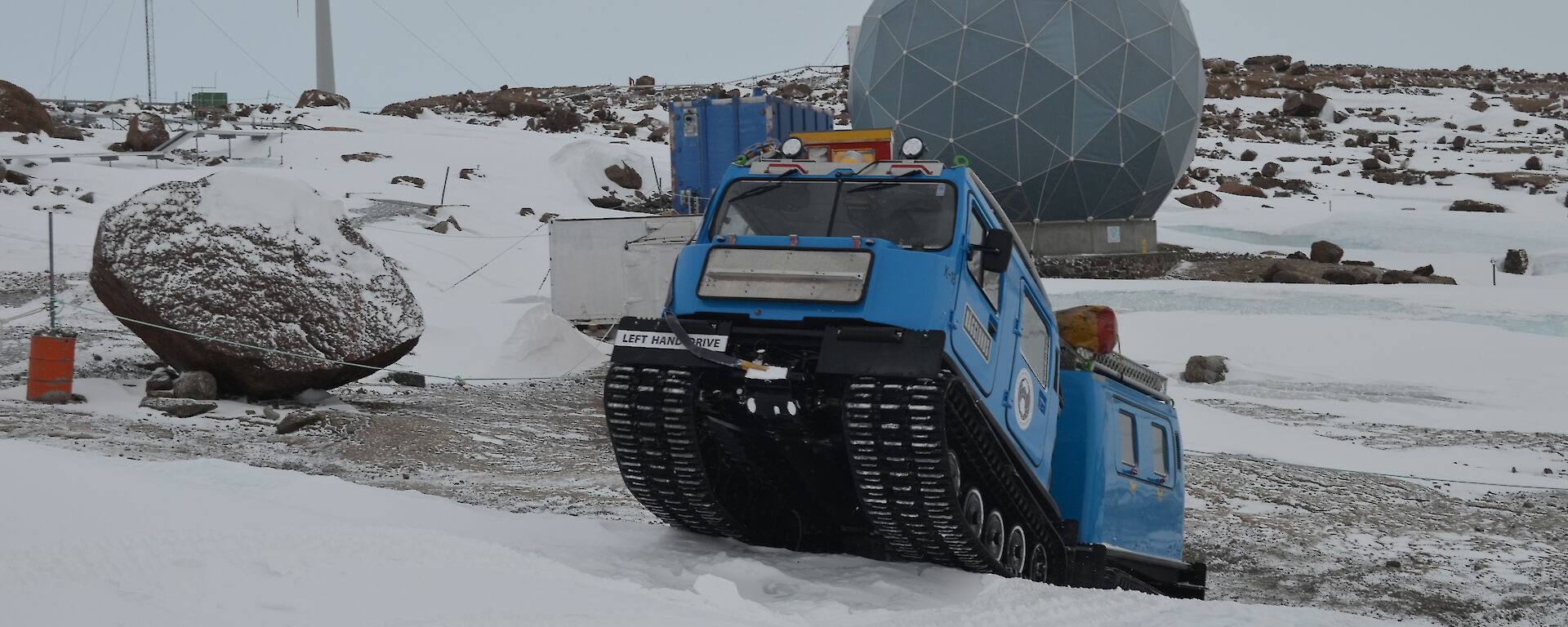Hägglunds oversnow vehicle driving around Mawson station
