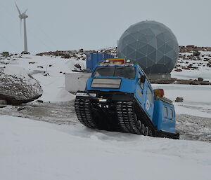 Hägglunds oversnow vehicle driving around Mawson station