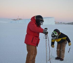 Expeditioners drilling the sea ice