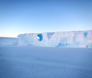 A trapped iceberg in the sea ice with an unusual formation — a hole in the side