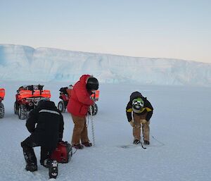 Expeditioners drilling the sea ice