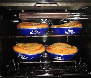 Four Fray Bentos meat pies cooking in the oven