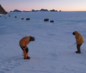 Expeditioners cutting steps into an icy slope