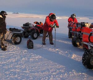 Expeditioners drilling the sea ice
