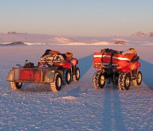 Four quad bikes stopped on the sea ice whilst an expeditioner assesses the map