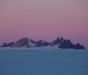 The sun rising with The David Range in the distance