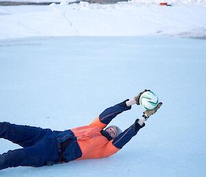 An expeditioner stages a goal saving dive to catch the ball