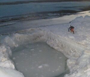 The sea ice quickly reforms with the swimming hole icing back over hours after being dug