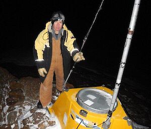 An expeditioner standing beside the radio repeater station