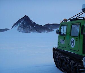 The Hägglunds heading out and onto the Antarctic plateau with Fang Peak in the distance