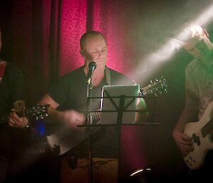 Three of the guitarists playing, with one of them also on vocals