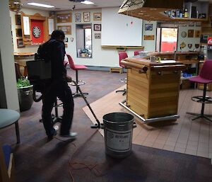 Saturday duties continues with an expeditioner vacuuming the bar area