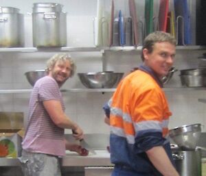 One expeditioner cutting onions and another washing dishes whilst on slushy duties